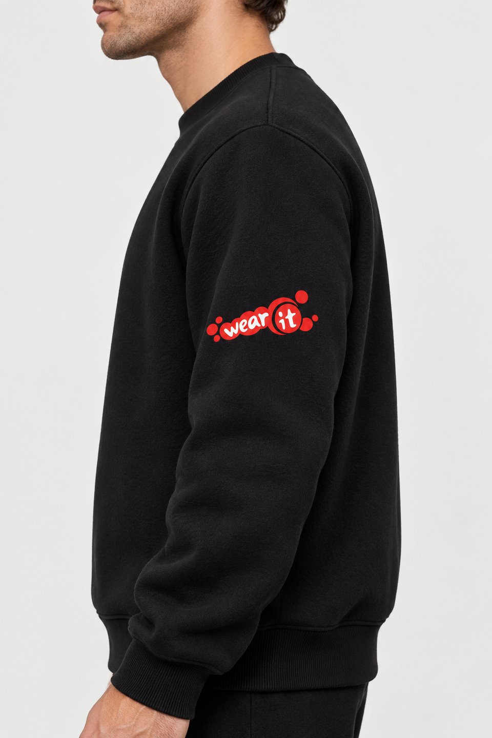 Sweat col rond noir Wear It vu de côté, petit logo rouge au milieu de la manche gauche
